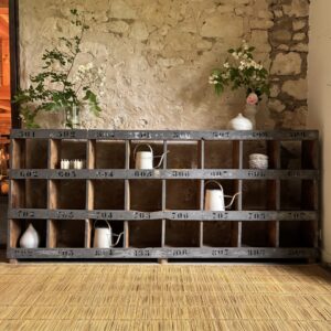 Étagère de métier vintage en bois patiné gris avec numéros peints et 24 compartiments de rangement.