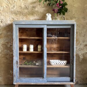 Petite vitrine avec deux portes coulissantes, sur pieds, patinée bleue.